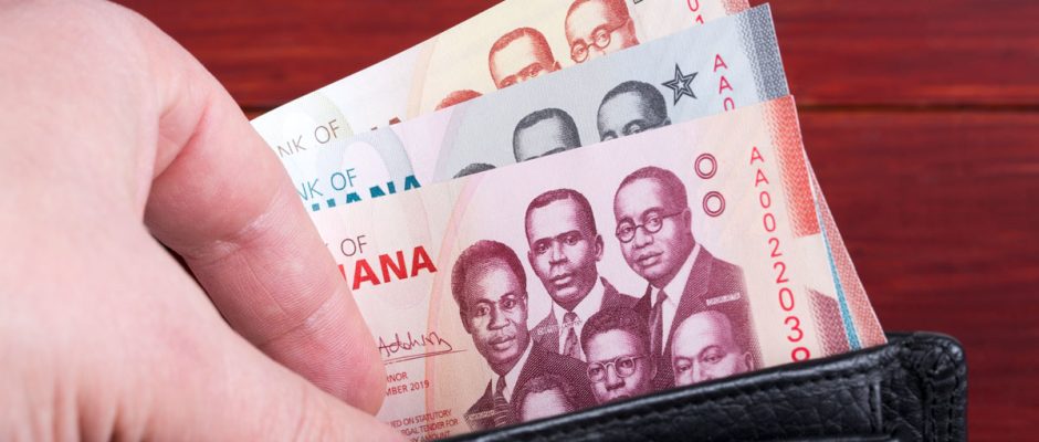 Ghanaian cedi banknotes tucked inside an open wallet, showing the colorful designs and denominations of Ghana’s currency.
