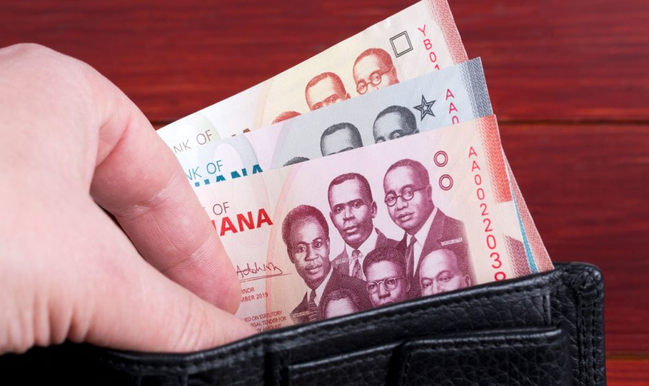 Ghanaian cedi banknotes tucked inside an open wallet, showing the colorful designs and denominations of Ghana’s currency.