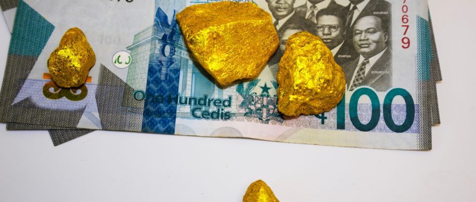 Gold nuggets on Ghanaian 100 cedi banknotes representing Ghana's gold mining industry and proposed royalty hike.