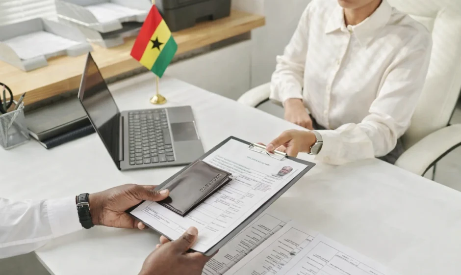 Ghana visa application process with Ghana flag on desk and passport documents