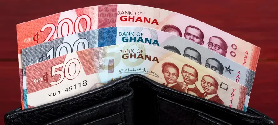 Ghana remittances wallet with Ghana cedi notes showing money sent to Ghana from abroad