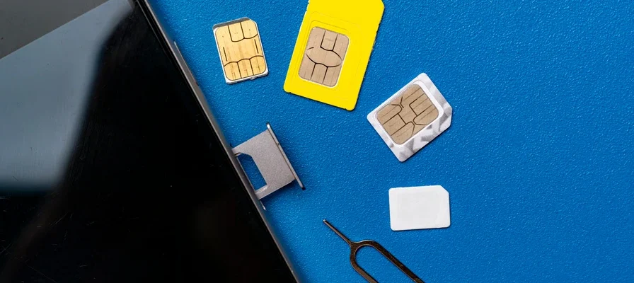 Smartphone with multiple SIM cards on a table representing SIM swap fraud in Ghana