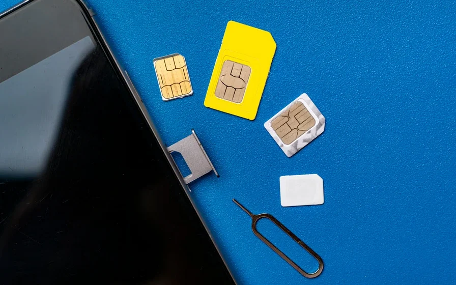 Smartphone with multiple SIM cards on a table representing SIM swap fraud in Ghana