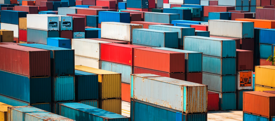 Shipping containers stacked at a busy cargo port, illustrating Ghana spare parts import duties and customs clearance delays.