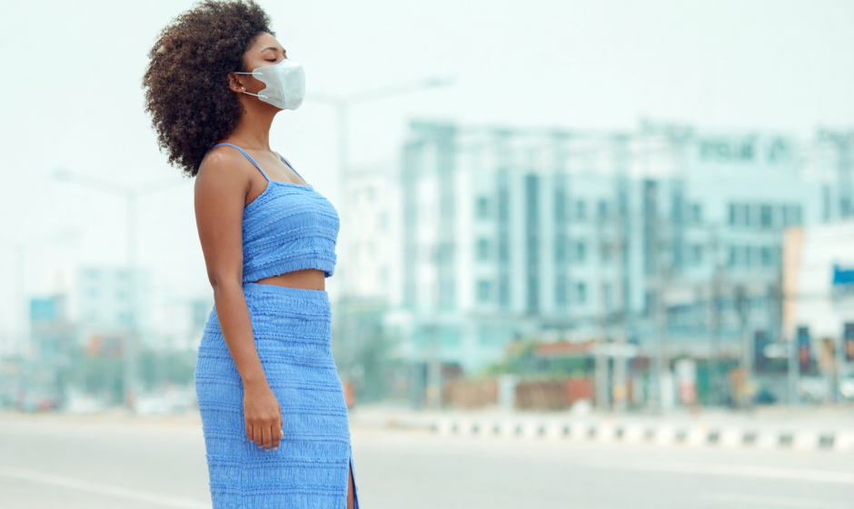 Woman outdoors in Accra Ghana with light haze in the air highlighting urban air quality conditions
