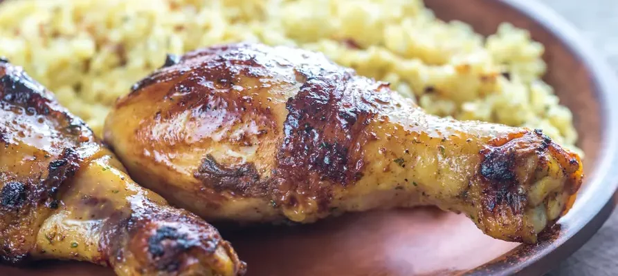 Traditional Ghanaian jollof rice served with baked chicken on a plate