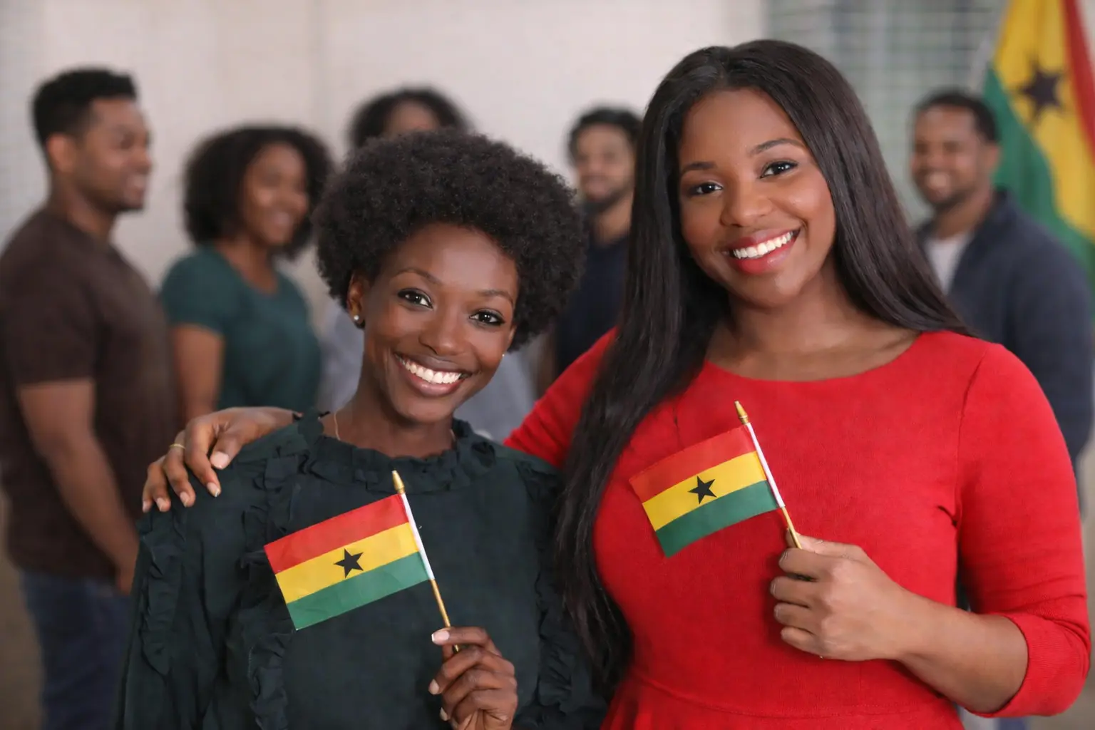 Ghana citizenship overview showing two women holding Ghana flags during a citizenship and identity celebration event
