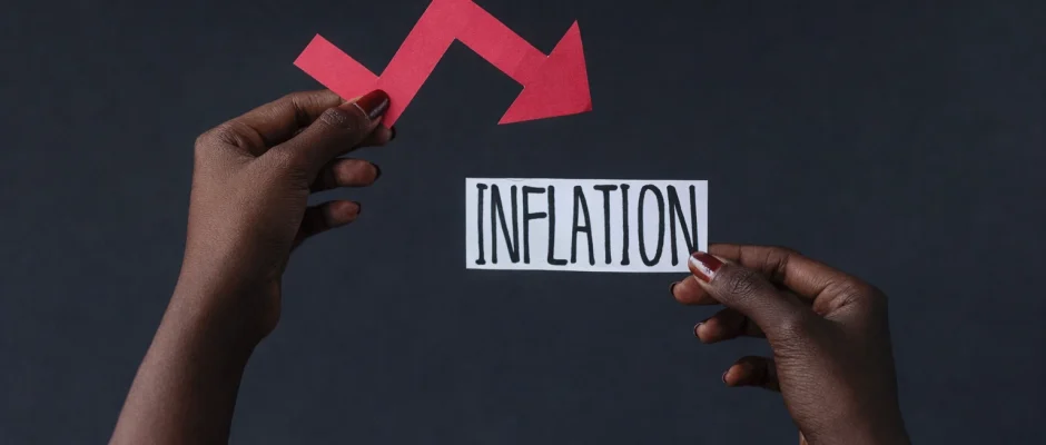 Hands holding inflation label with downward arrow showing inflation decline in Ghana