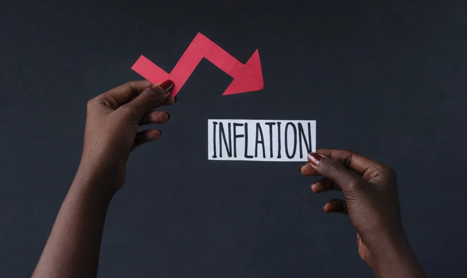 Hands holding inflation label with downward arrow showing inflation decline in Ghana