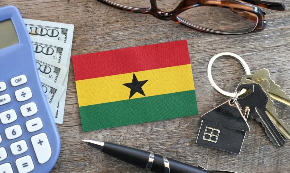 Ghana flag with house keys, calculator and US dollar bills representing the dollar rent ban