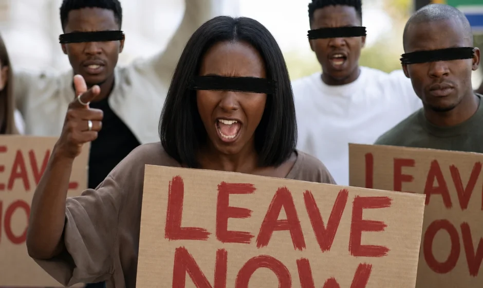 Protesters holding signs during unrest linked to xenophobic attacks in South Africa (simulated image)