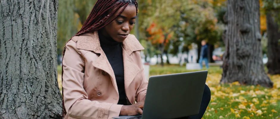 Young woman using a laptop for digital skills training in Ghana One Million Coders Program.