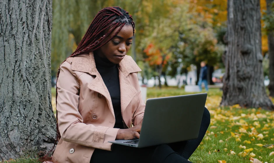Young woman using a laptop for digital skills training in Ghana One Million Coders Program.
