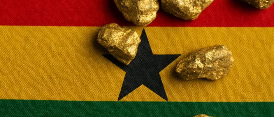 Gold nuggets resting on a Ghana flag representing legal gold buying and trading in Ghana
