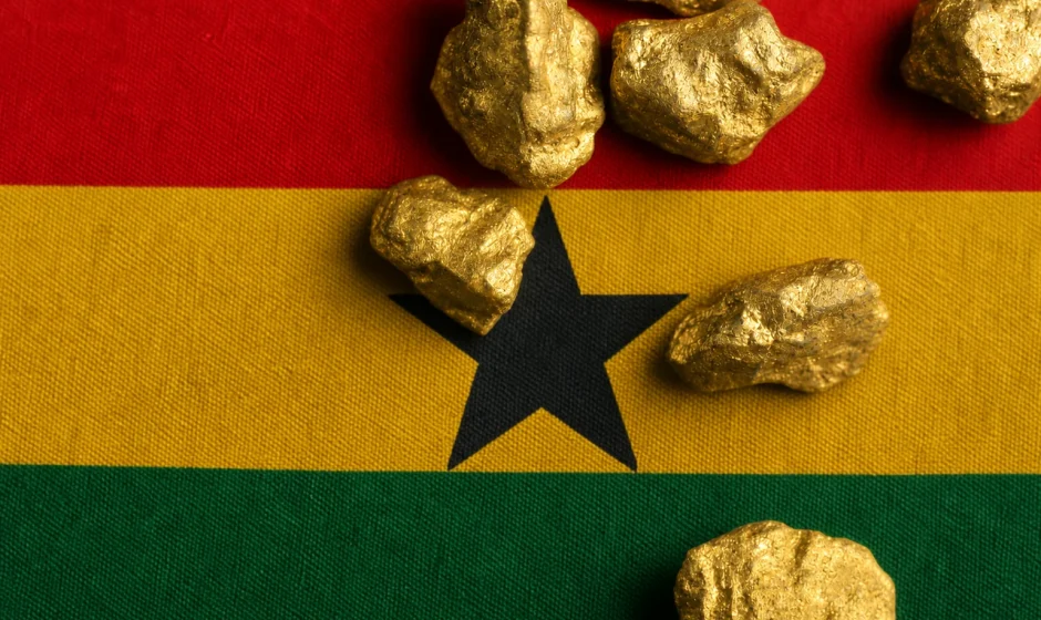 Gold nuggets resting on a Ghana flag representing legal gold buying and trading in Ghana