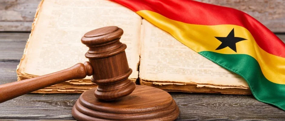 Gavel and generic law book sitting on top of a Ghana flag