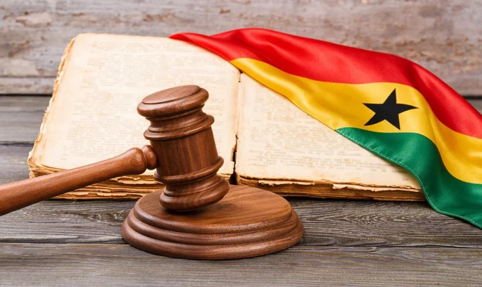 Gavel and generic law book sitting on top of a Ghana flag