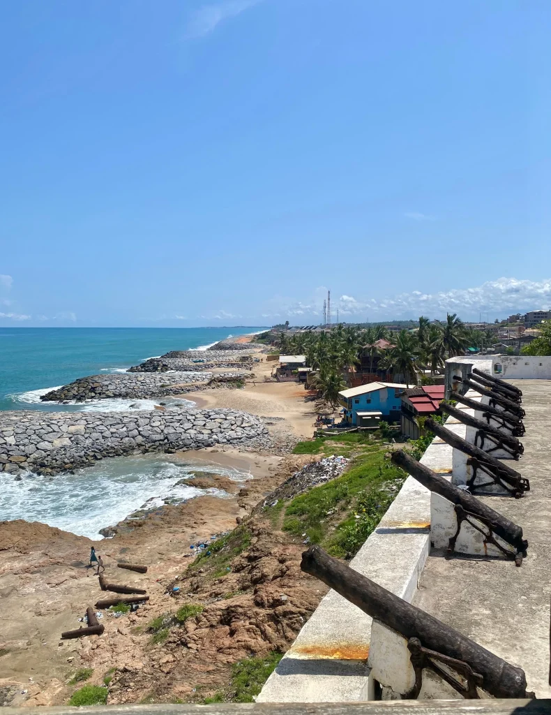 Scenic view of the coast with historical cannons overlooking the ocean at Cape Coast Castle, Ghana.