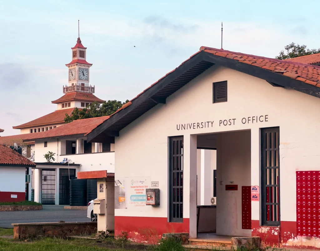 Charming university post office with a clock tower in a serene setting, representing academic architecture.